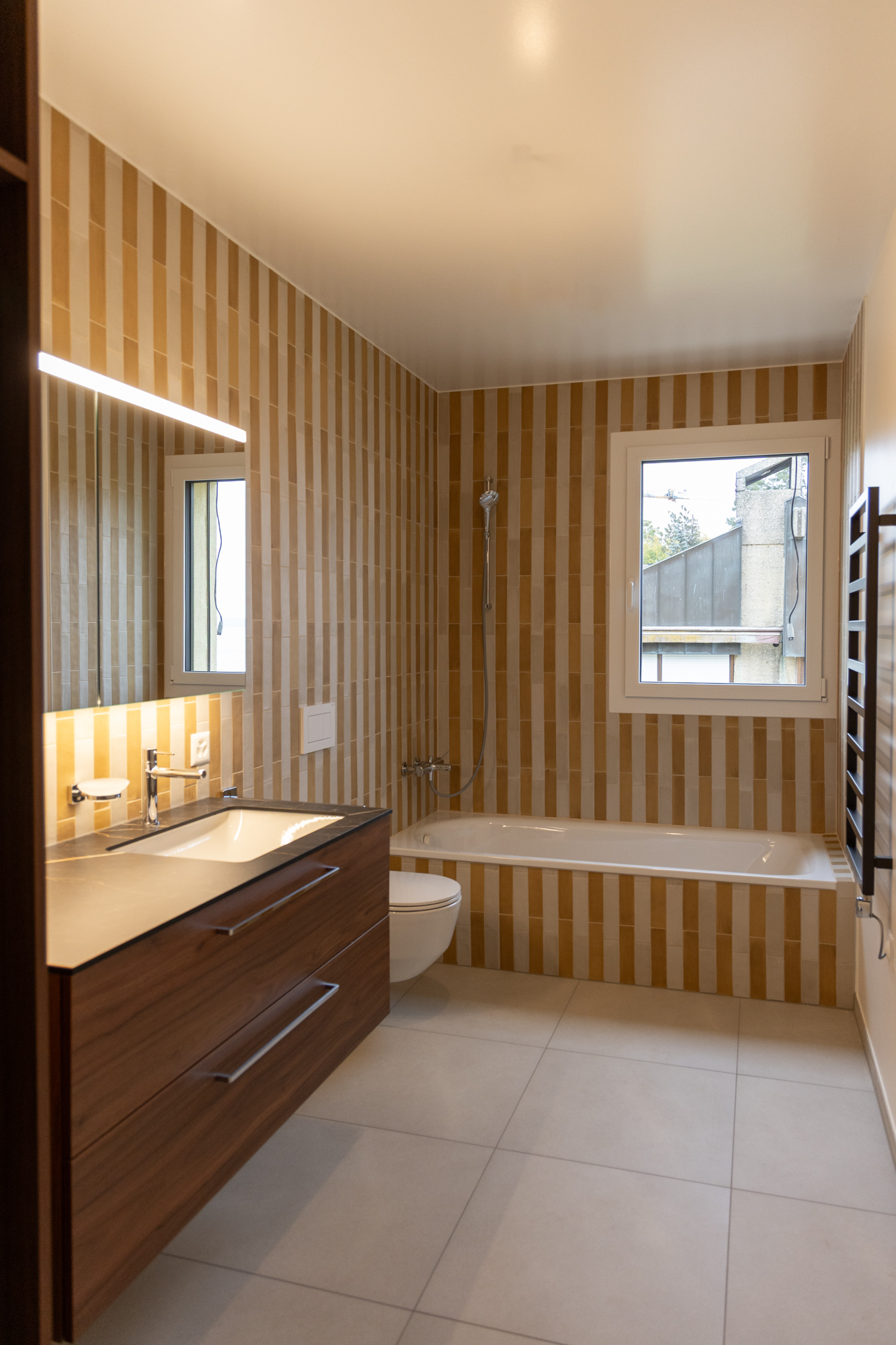 Villa familiale contemporaine au bord du lac Léman, architecture moderne Vaud, intérieur design, béton brut, bois et détails sur mesure salle de bains enfants