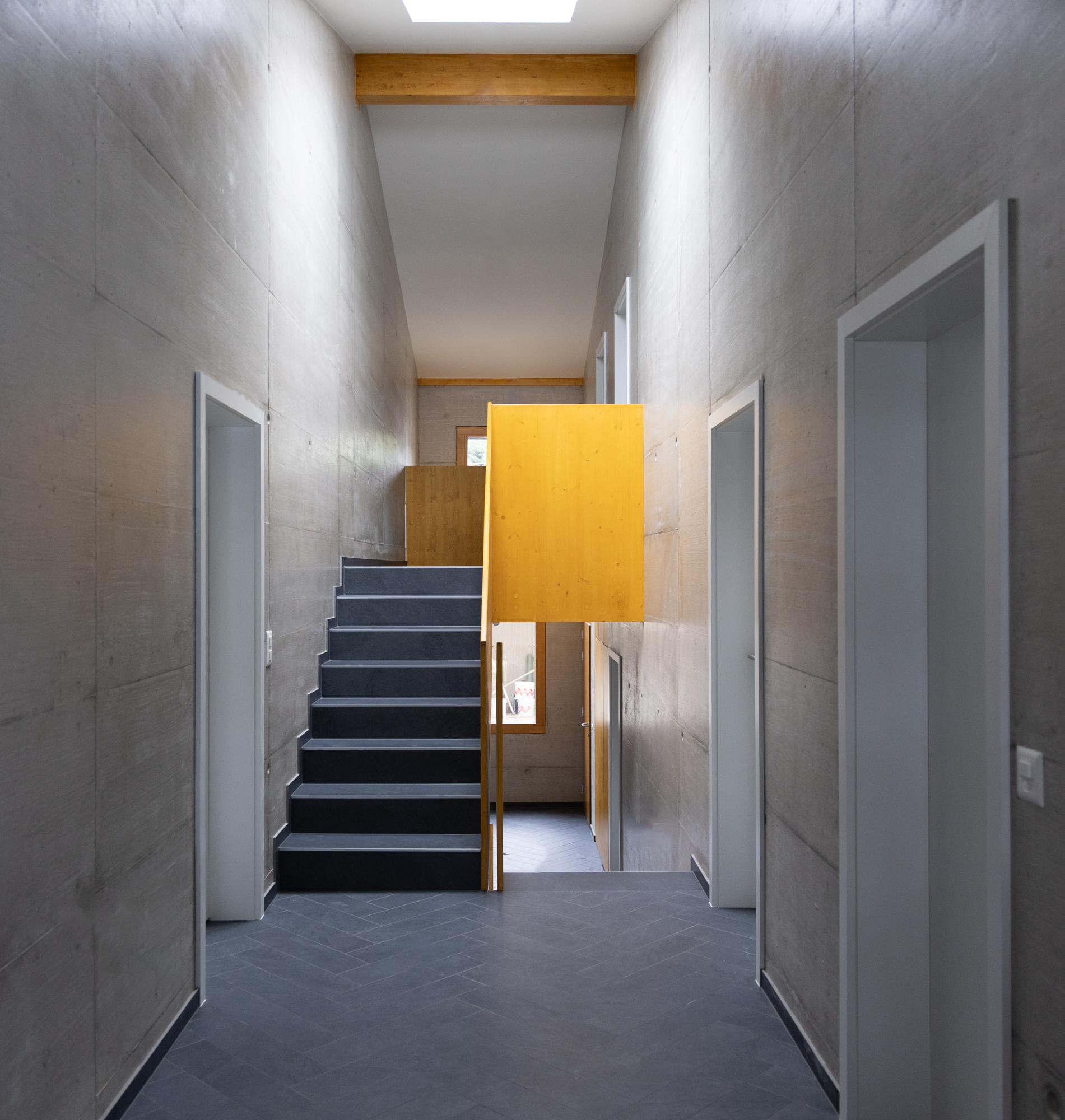 Villa familiale contemporaine au bord du lac Léman, architecture moderne Vaud, intérieur design, béton brut, bois et détails sur mesure couloir