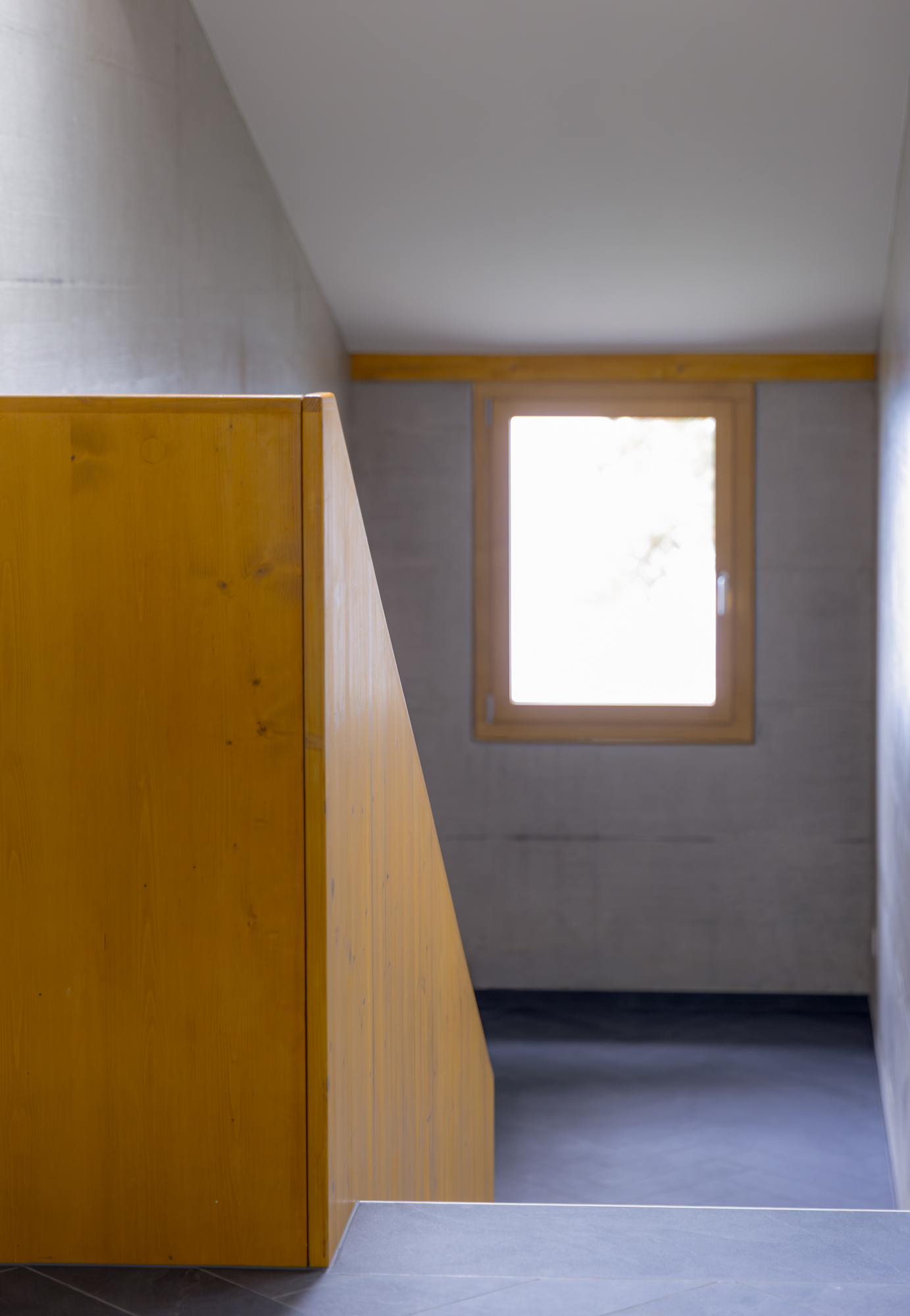 Villa familiale contemporaine au bord du lac Léman, architecture moderne Vaud, intérieur design, béton brut, bois et détails sur mesure main courante