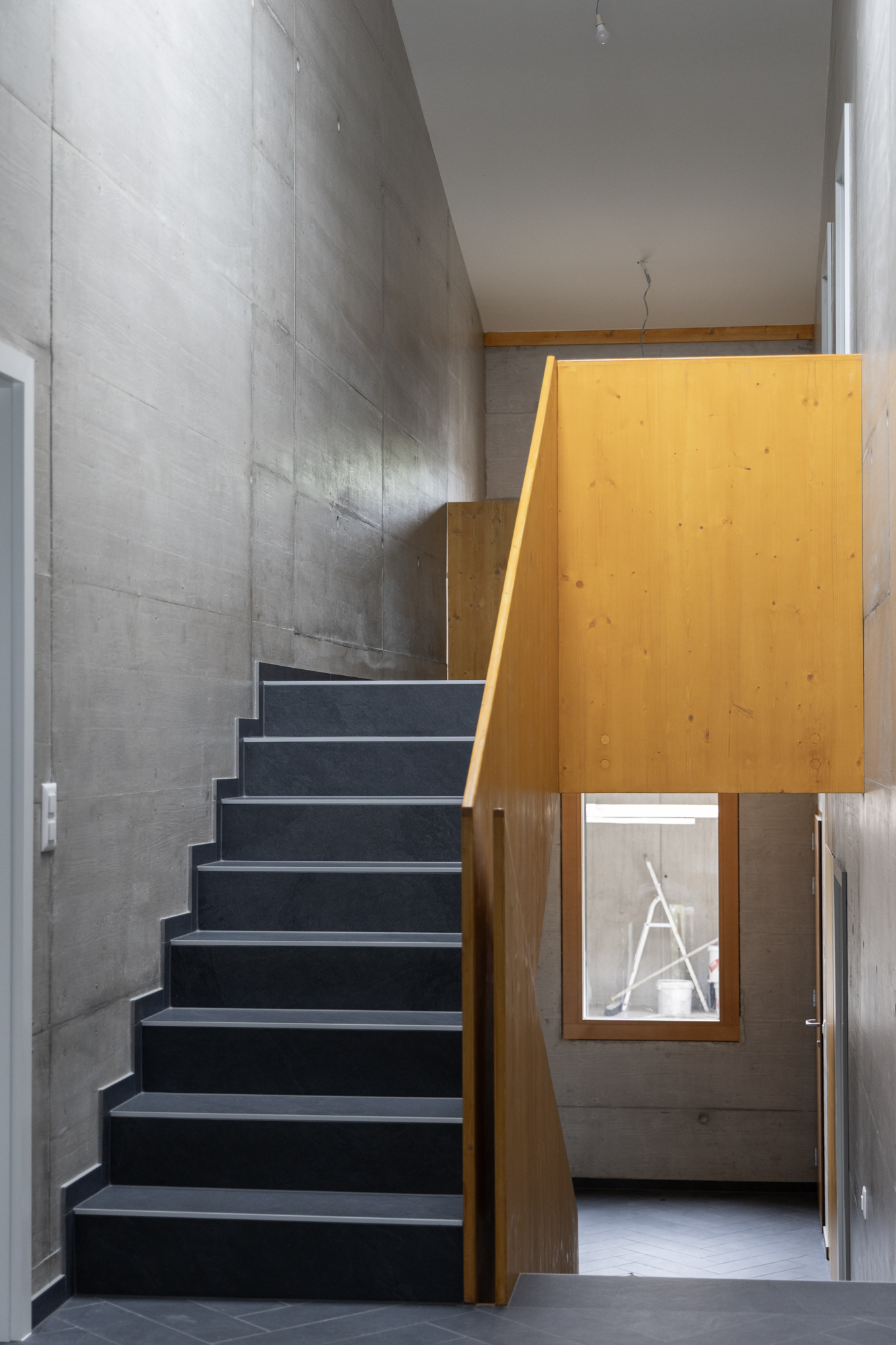 Villa familiale contemporaine au bord du lac Léman, architecture moderne Vaud, intérieur design, béton brut, bois et détails sur mesure escalier